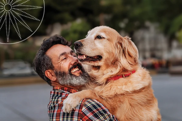 man holding his dog and smiling